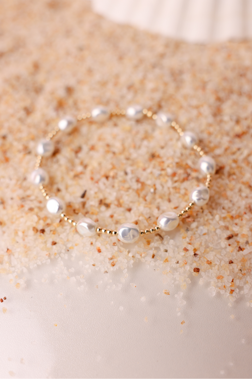 Pearl bracelet on a textured beige surface