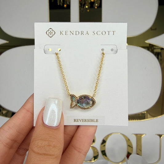 Hand holding a Kendra Scott necklace on a branded card with decorative background