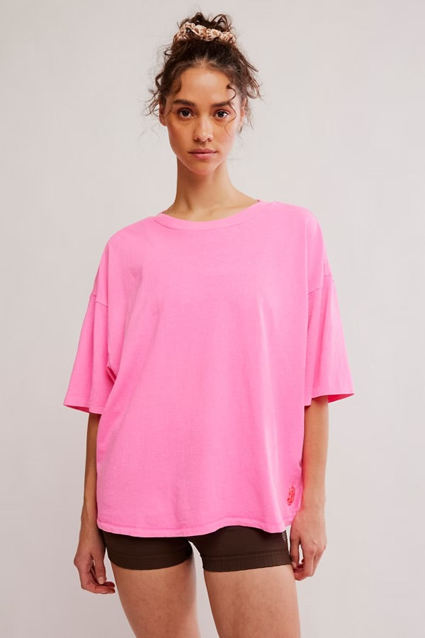 Model wearing Pink Top with brown biker shorts facing forwards