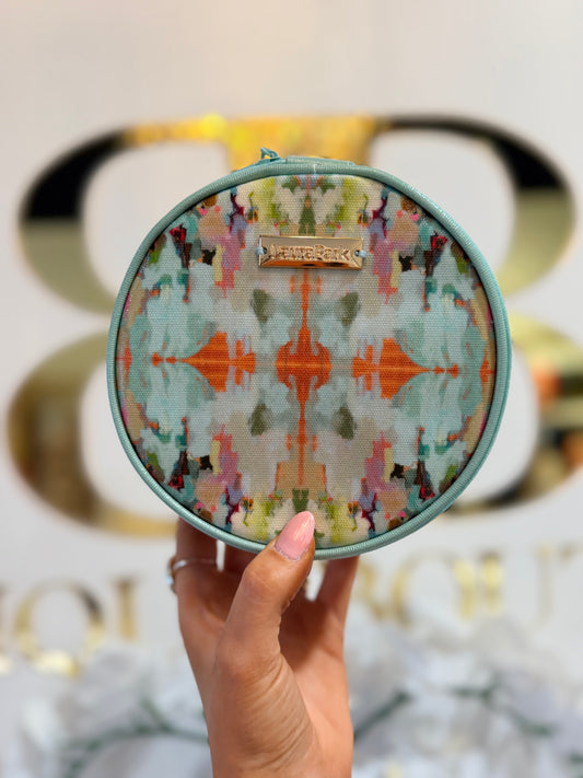 Round colorful patterned pouch held by a hand with a blurred background