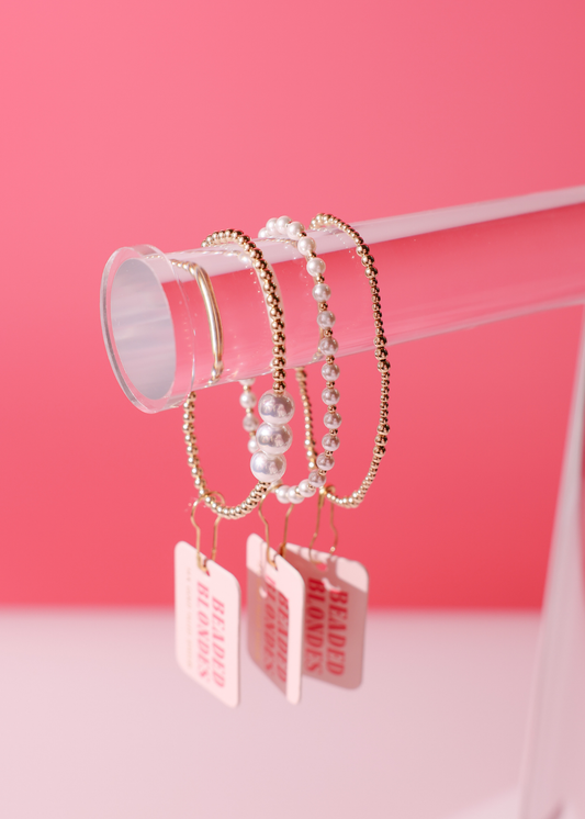 Set of bracelets with tags on a pink background