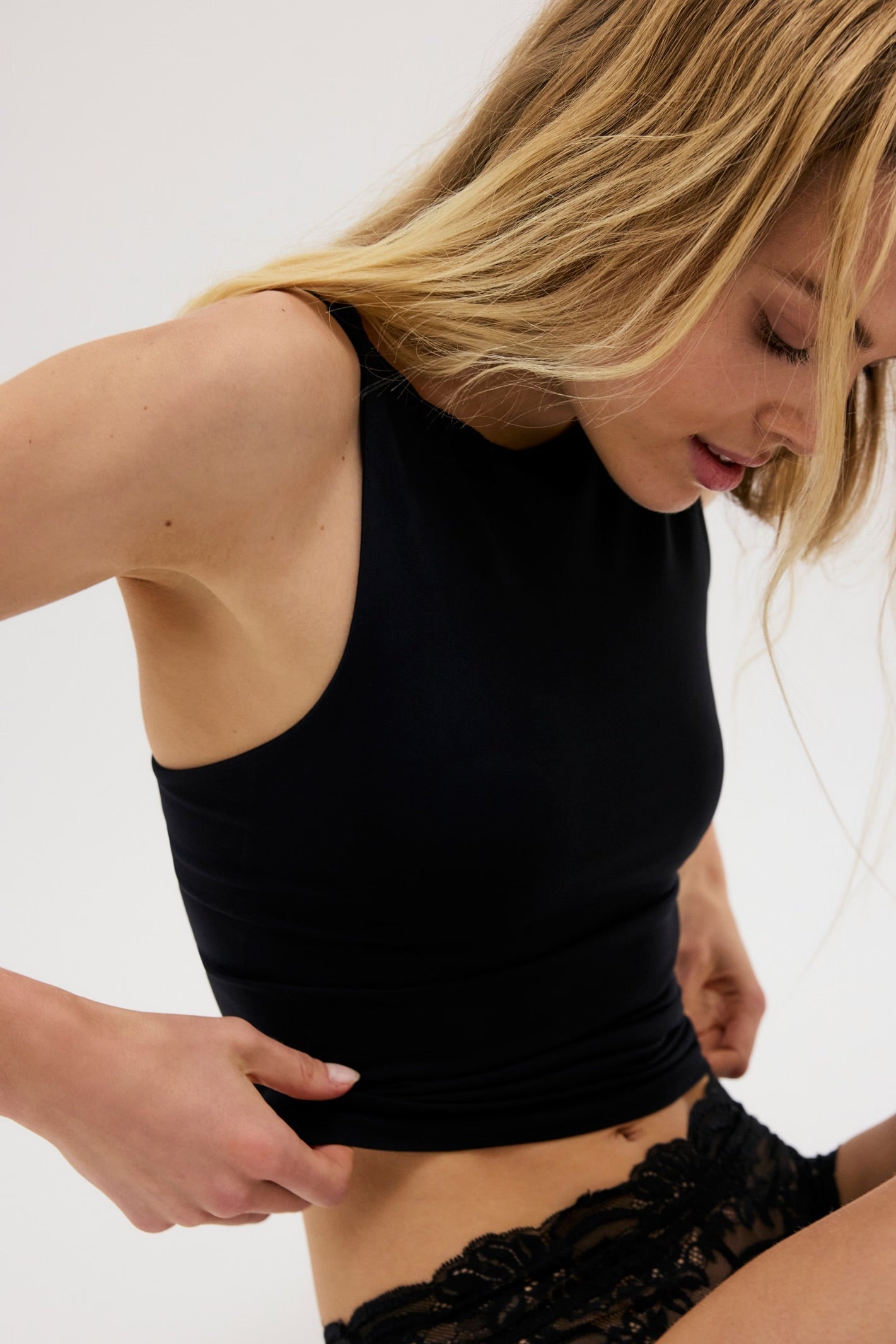 Model wearing black tank facing side ways