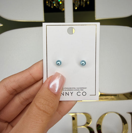 Hand holding a card with earrings on a blurred background