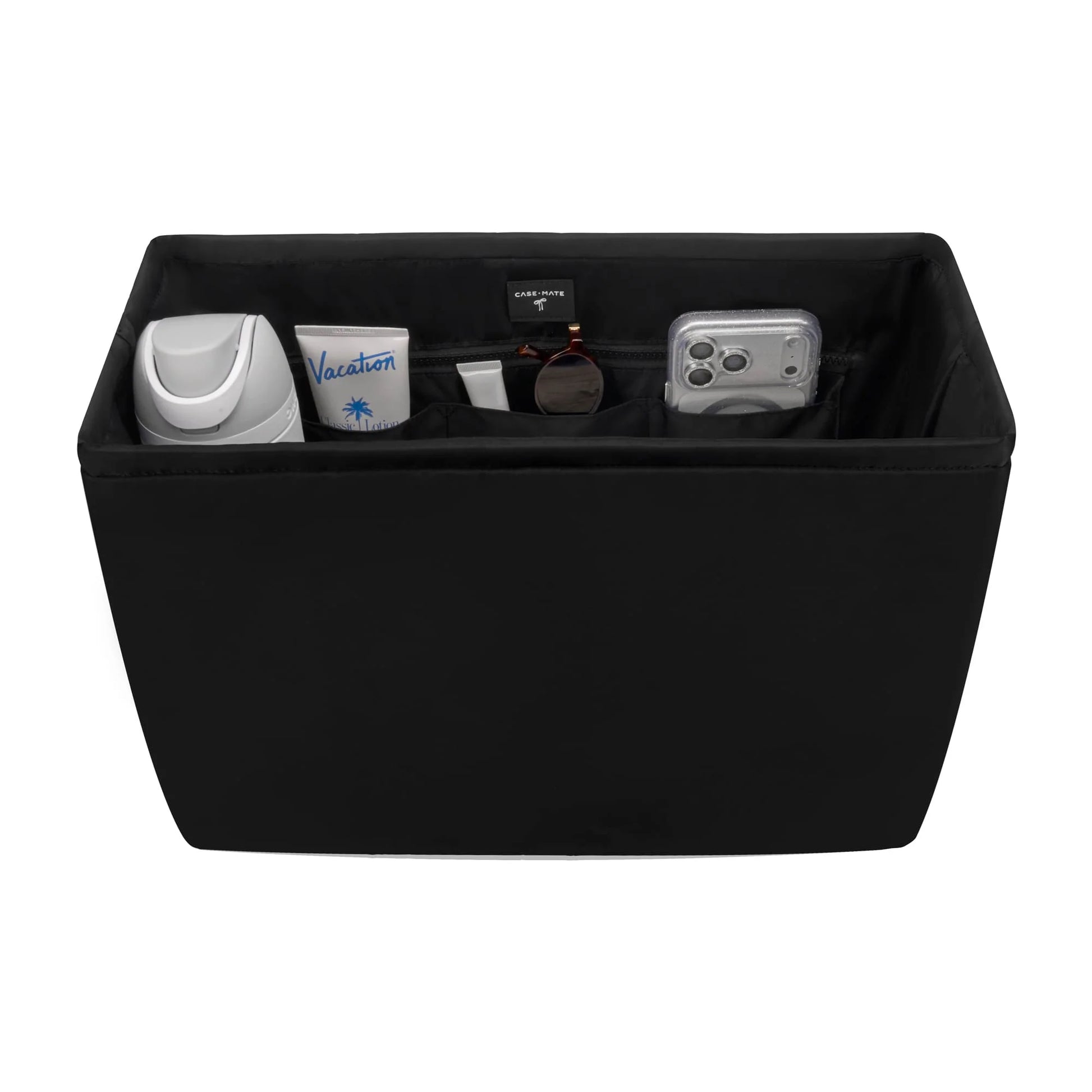 Black storage ottoman with various items on a white background