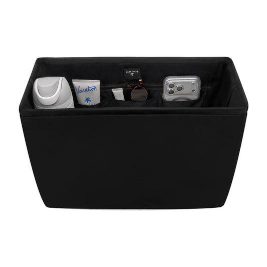 Black storage ottoman with various items on a white background