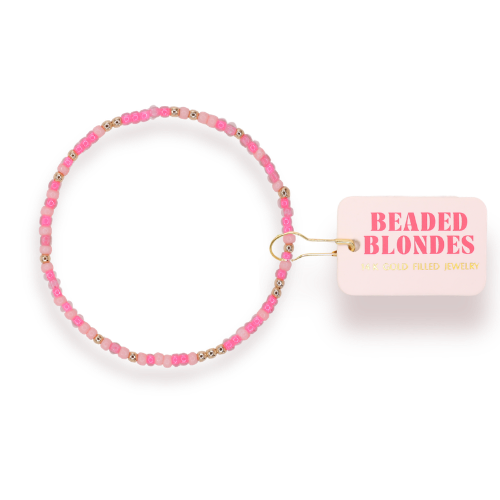 Pink beaded bracelet with 'Beaded Blondes' packaging on a white background
