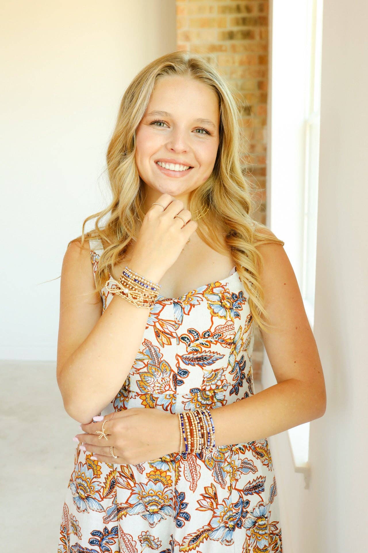 Woman wearing a floral dress with bracelets indoors