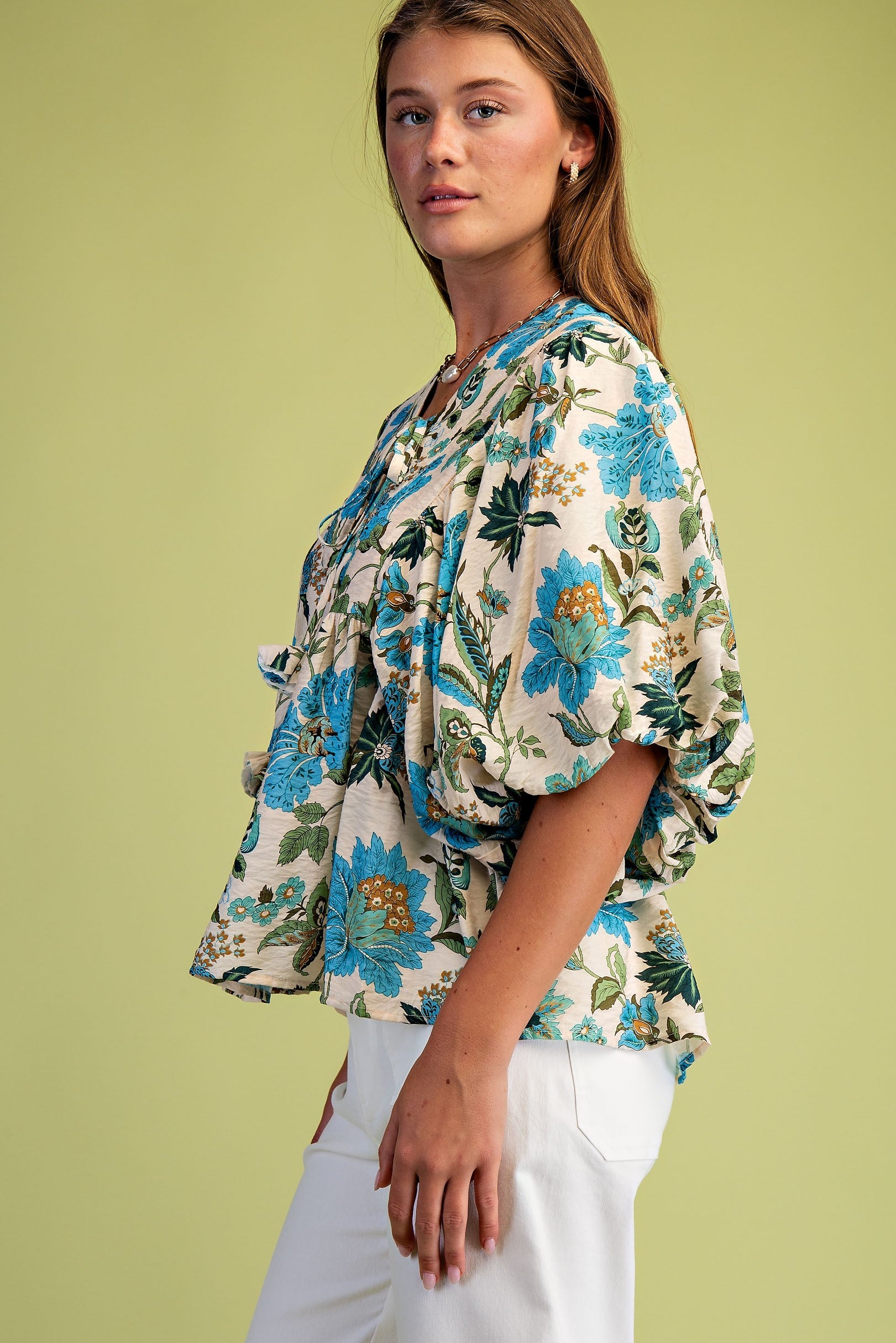 Woman wearing a floral blouse with a green background