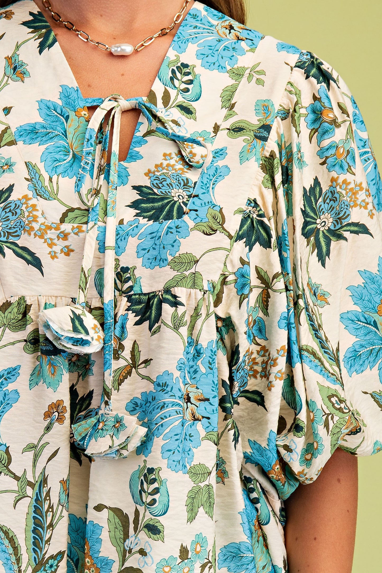 Floral patterned dress with blue and green flowers on a beige background