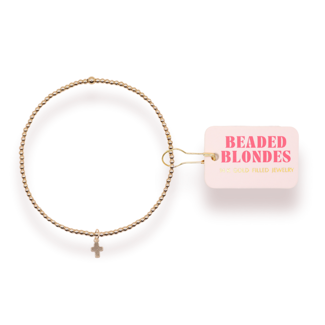 Gold bracelet with a small charm on a white background, featuring 'Beaded Blondes' packaging.