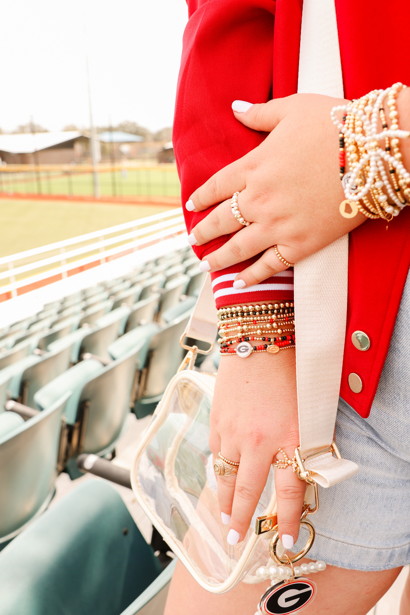 Close-up of hands with jewelry at a sports stadium