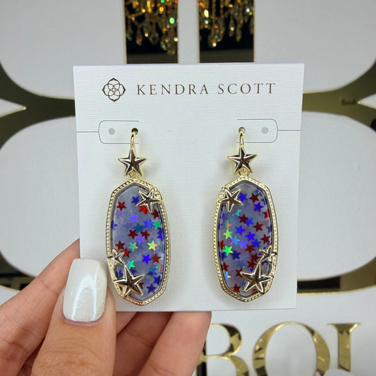 Kendra Scott earrings held on a branded card with a blurred background