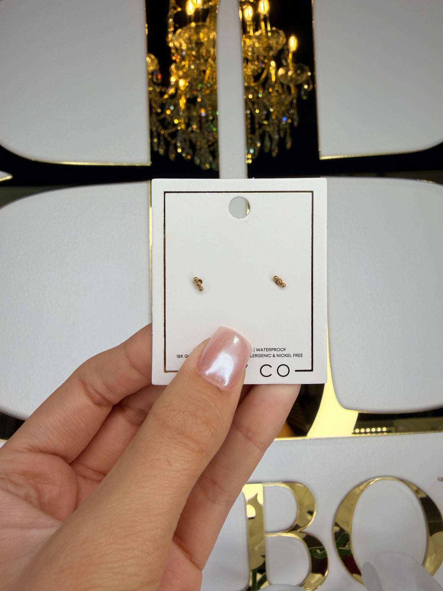 Linny co stud gold earrings infront of bb sign 