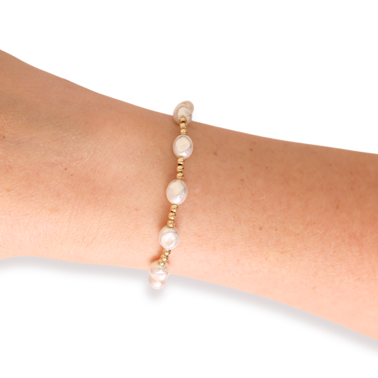 Pearl bracelet on a wrist against a white background