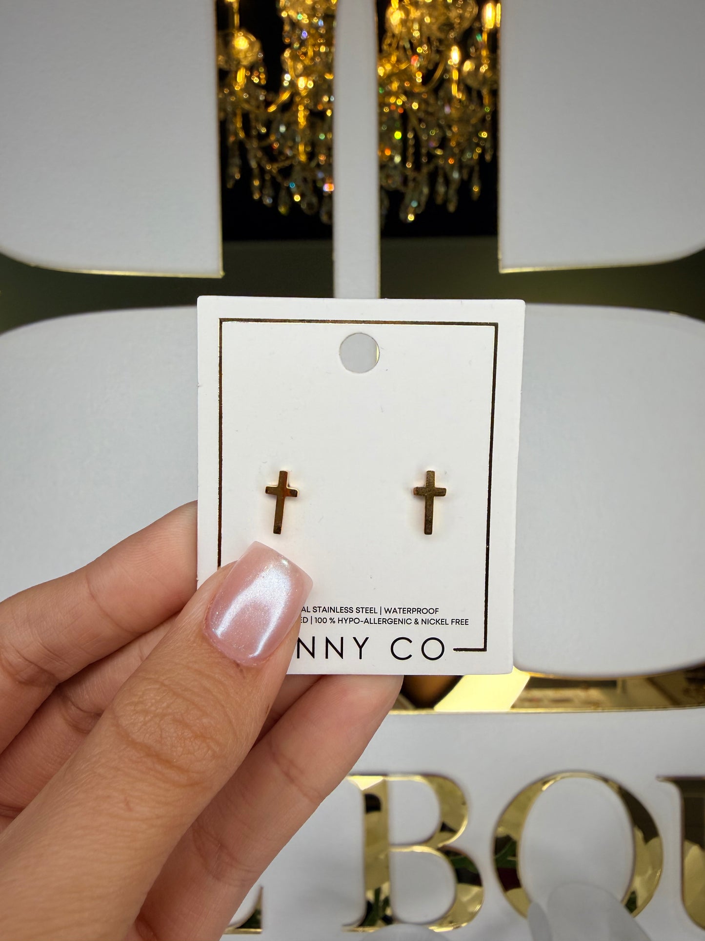 Hand holding a product with a visible brand label against a blurred decorative background