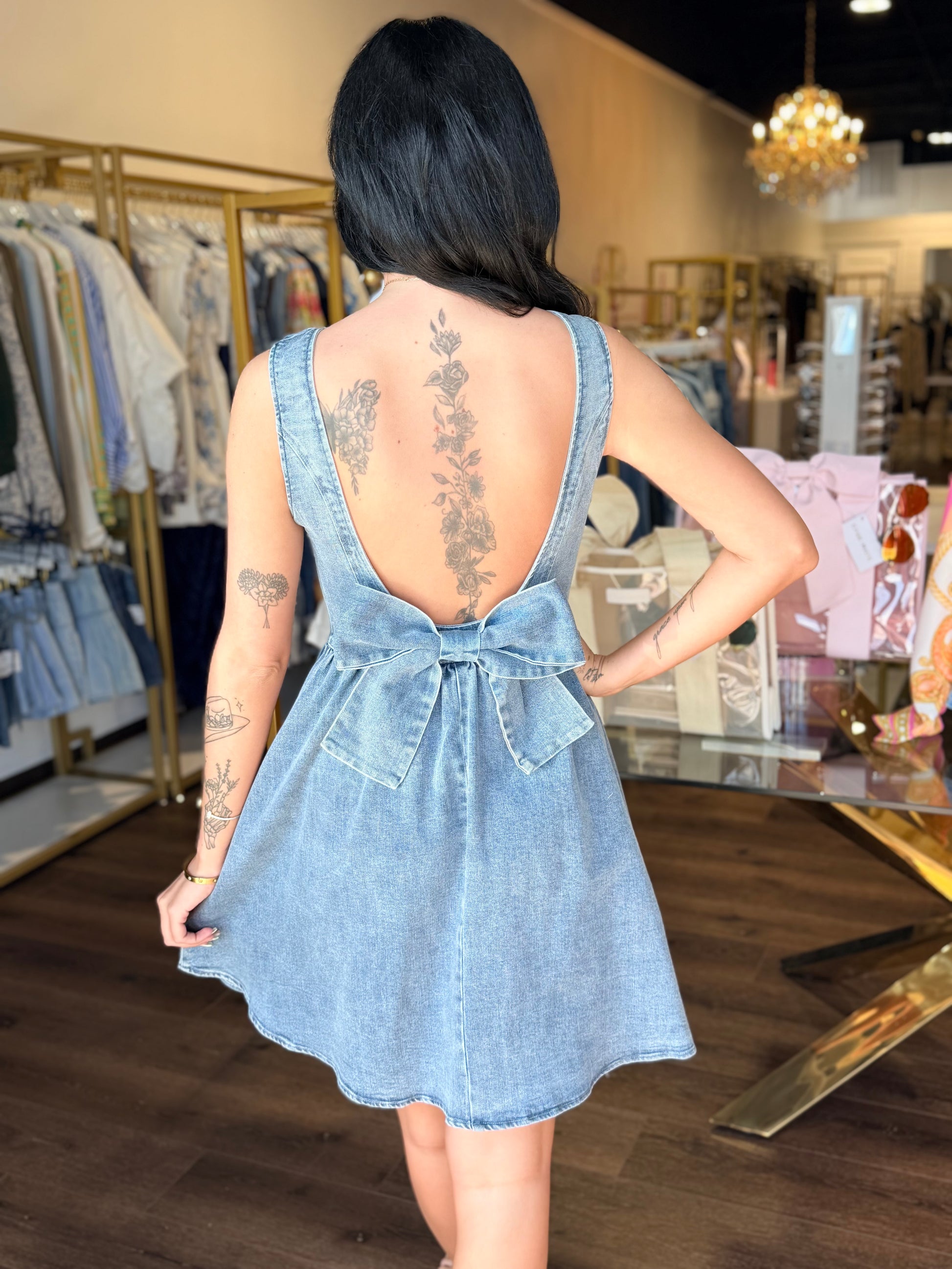 Model in denim dress and bow on the back 