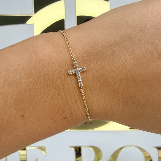 Gold bracelet on a wrist with a decorative background