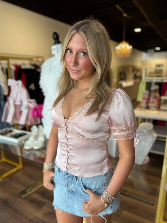 Britique model wearing pink silk top with boutique store background 