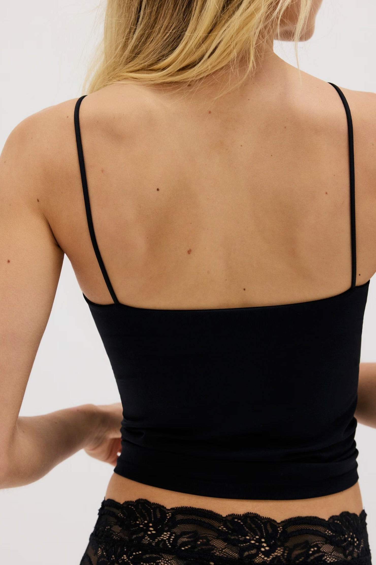 Model wearing black tank top back backwards