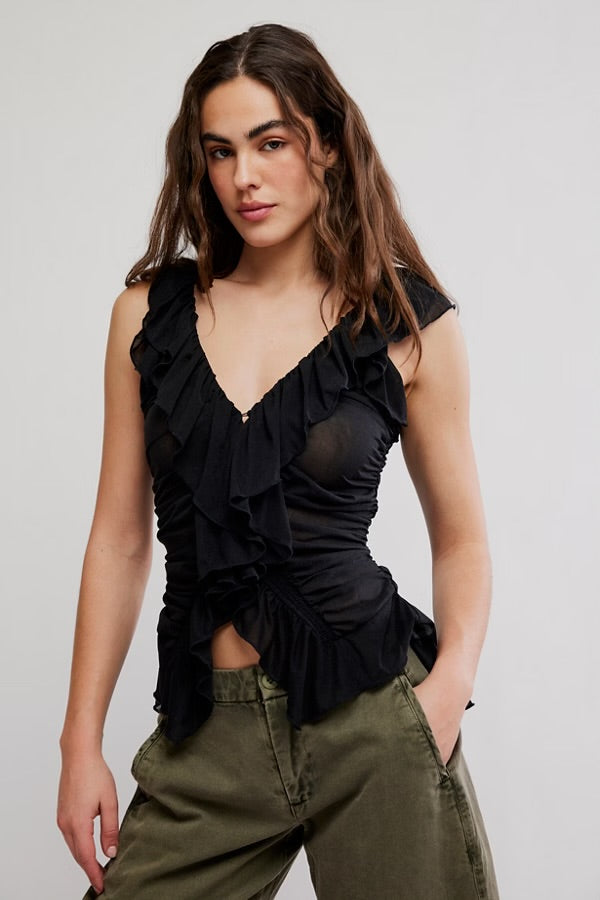 Model wearing black flowy tank top with green jeans facing forwards