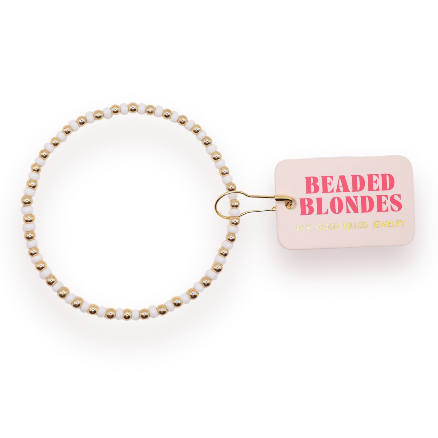 A beaded stretch bracelet with white beads and gold-toned spacer beads, attached to a small pink tag that reads 'BEADED BLONDE JEWELRY' in pink and gold lettering, on a white background.