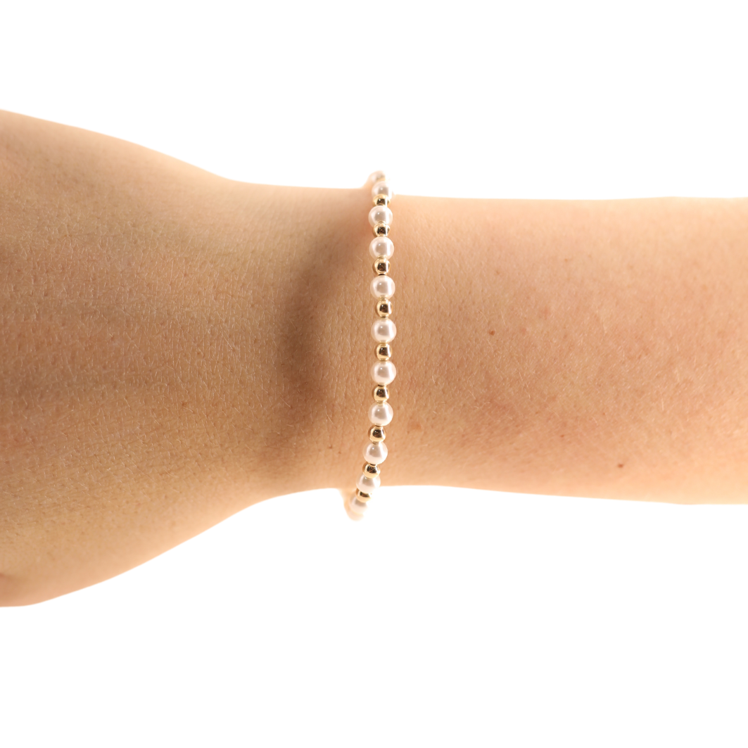 Pearl bracelet on a person's wrist against a white background