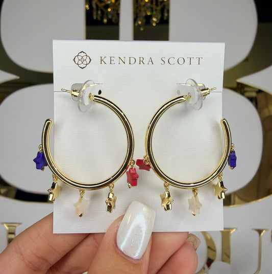 Gold hoop earrings on a Kendra Scott card held by a hand.