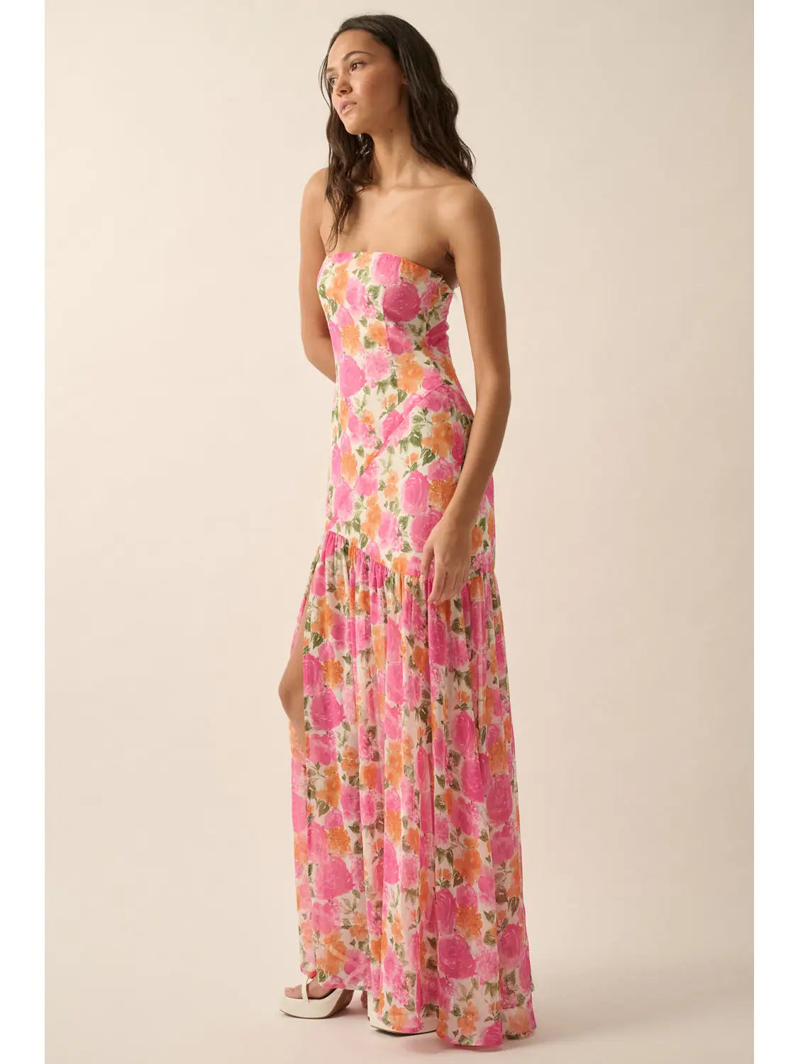Woman wearing a strapless floral dress on a beige background