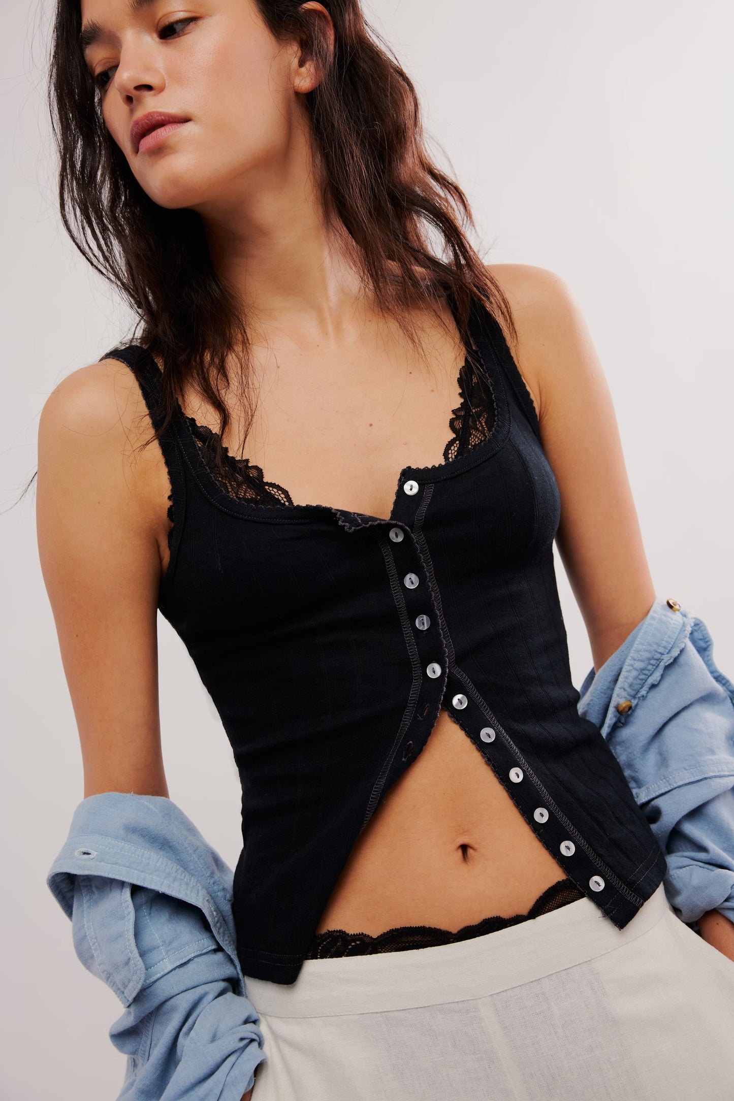 Woman wearing a black lace top with a white background