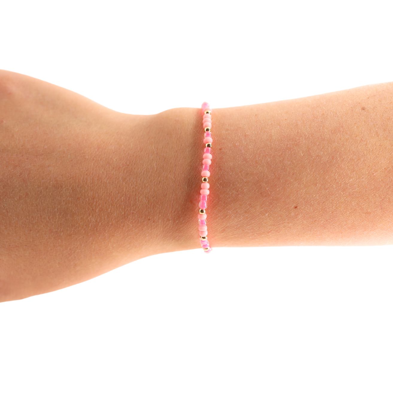 Pink beaded bracelet on a wrist against a white background