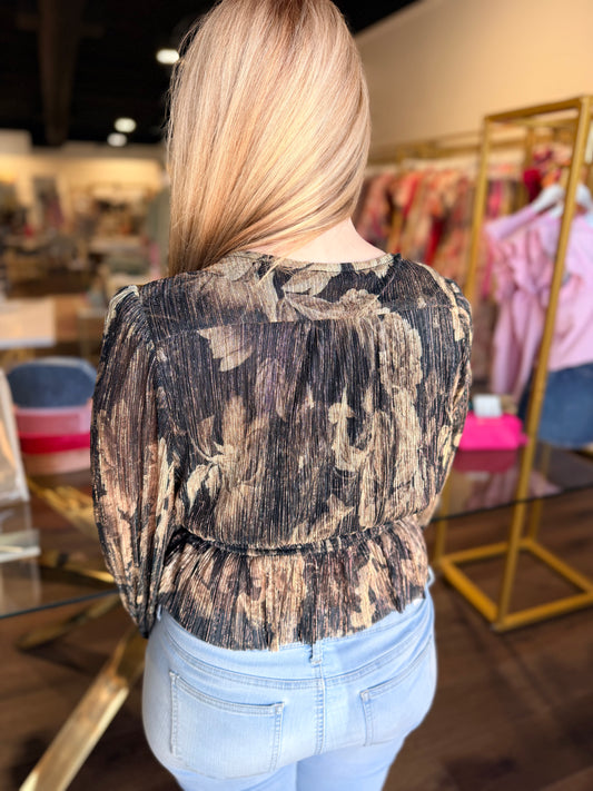 Person wearing a patterned top and light blue jeans in a store setting