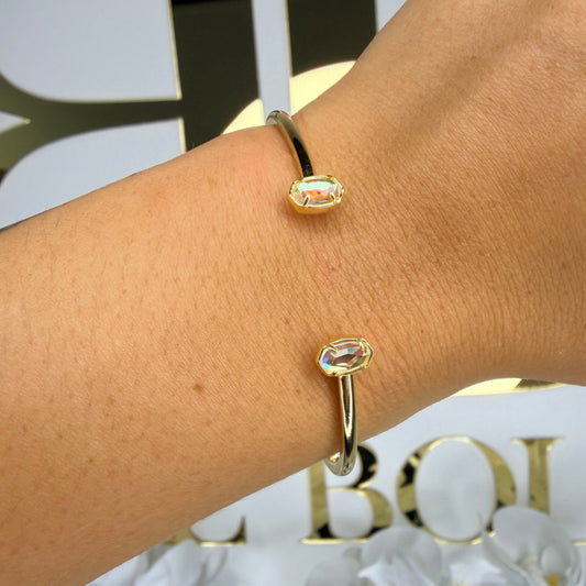 Kendra Scott cuff in gold infront of BB sign 