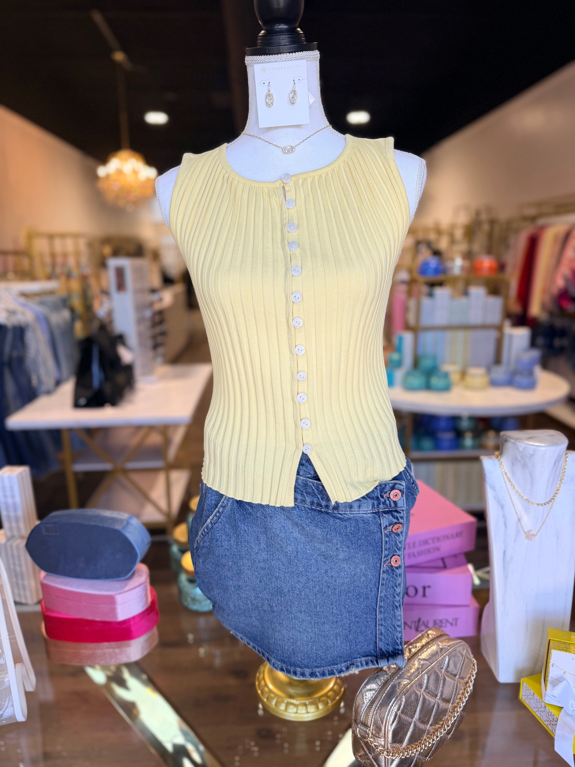 Picture of till yellow vest with blue jean skirt on table 