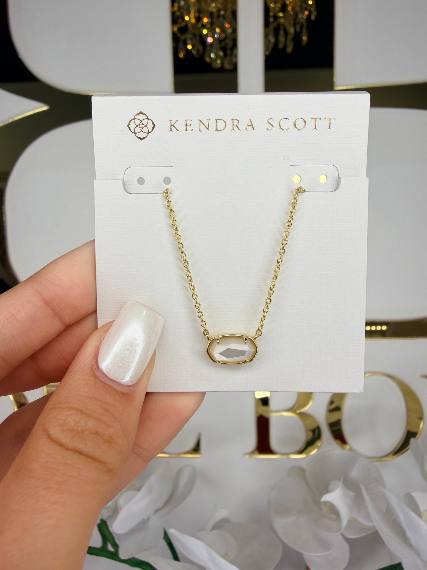 gold Kendra Scott necklace with white pendant
