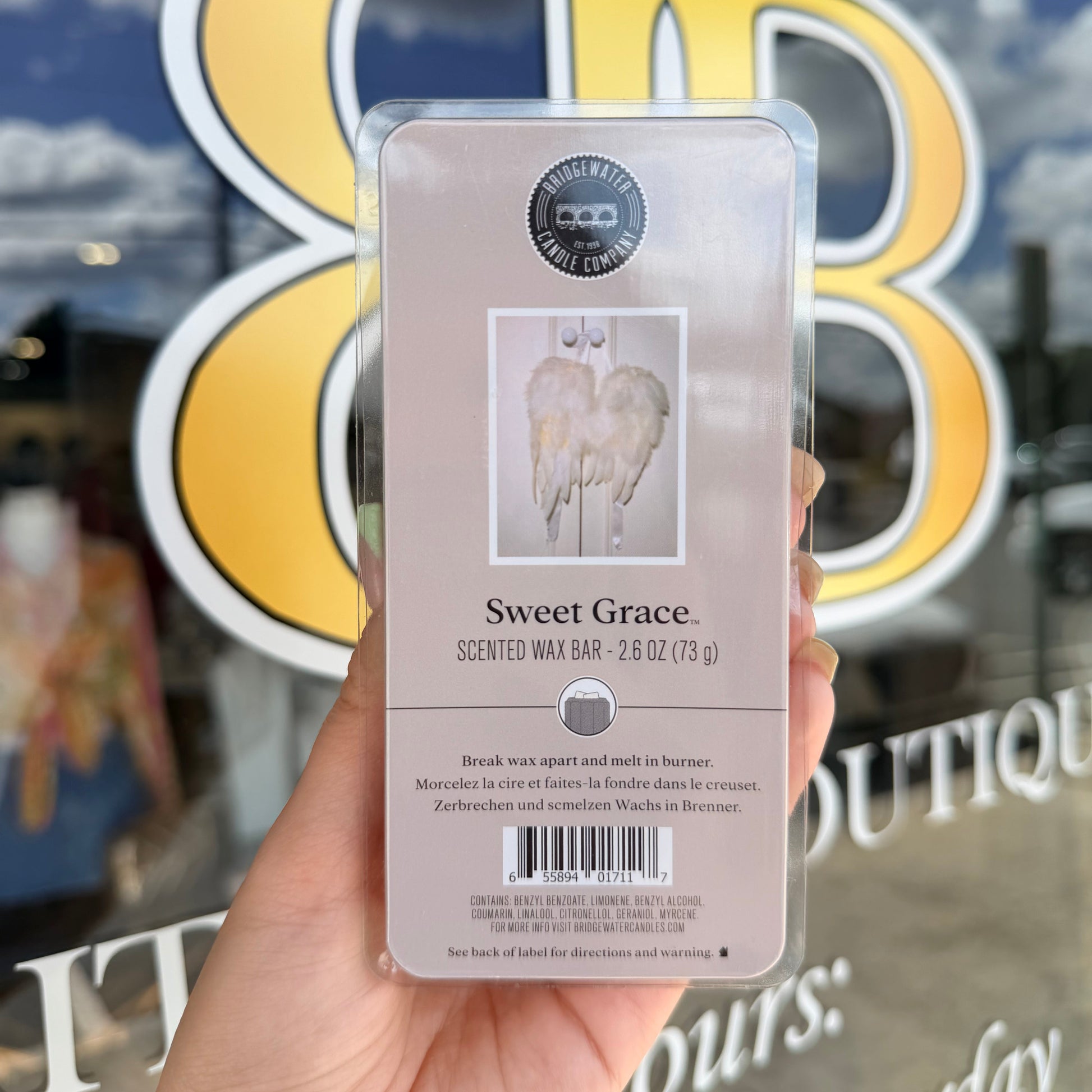 Hand holding a product packaging with 'Sweet Grace' branding against a blurred background