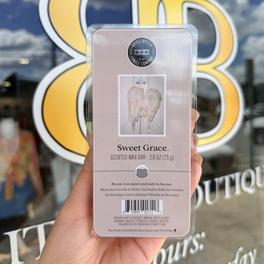 Hand holding a product packaging with 'Sweet Grace' branding against a blurred background