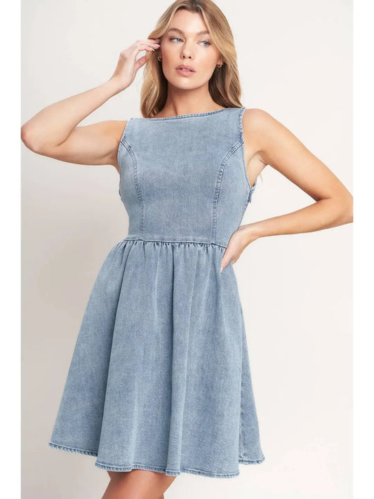 Woman wearing a light blue denim dress against a plain background