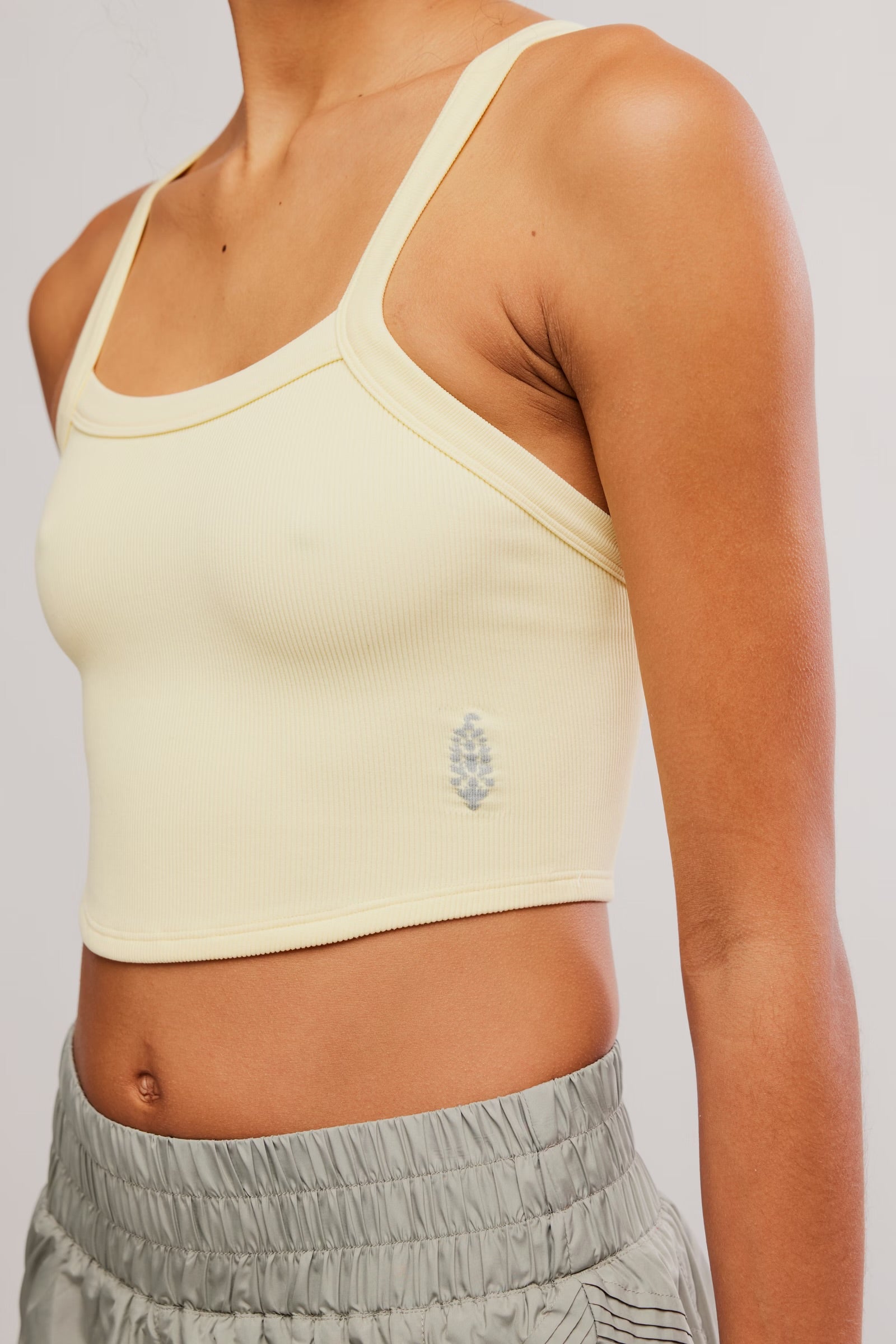 Yellow sports bra with a brand logo on a plain background