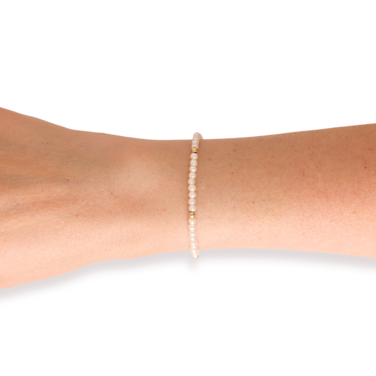 Pearl bracelet on a person's wrist against a white background