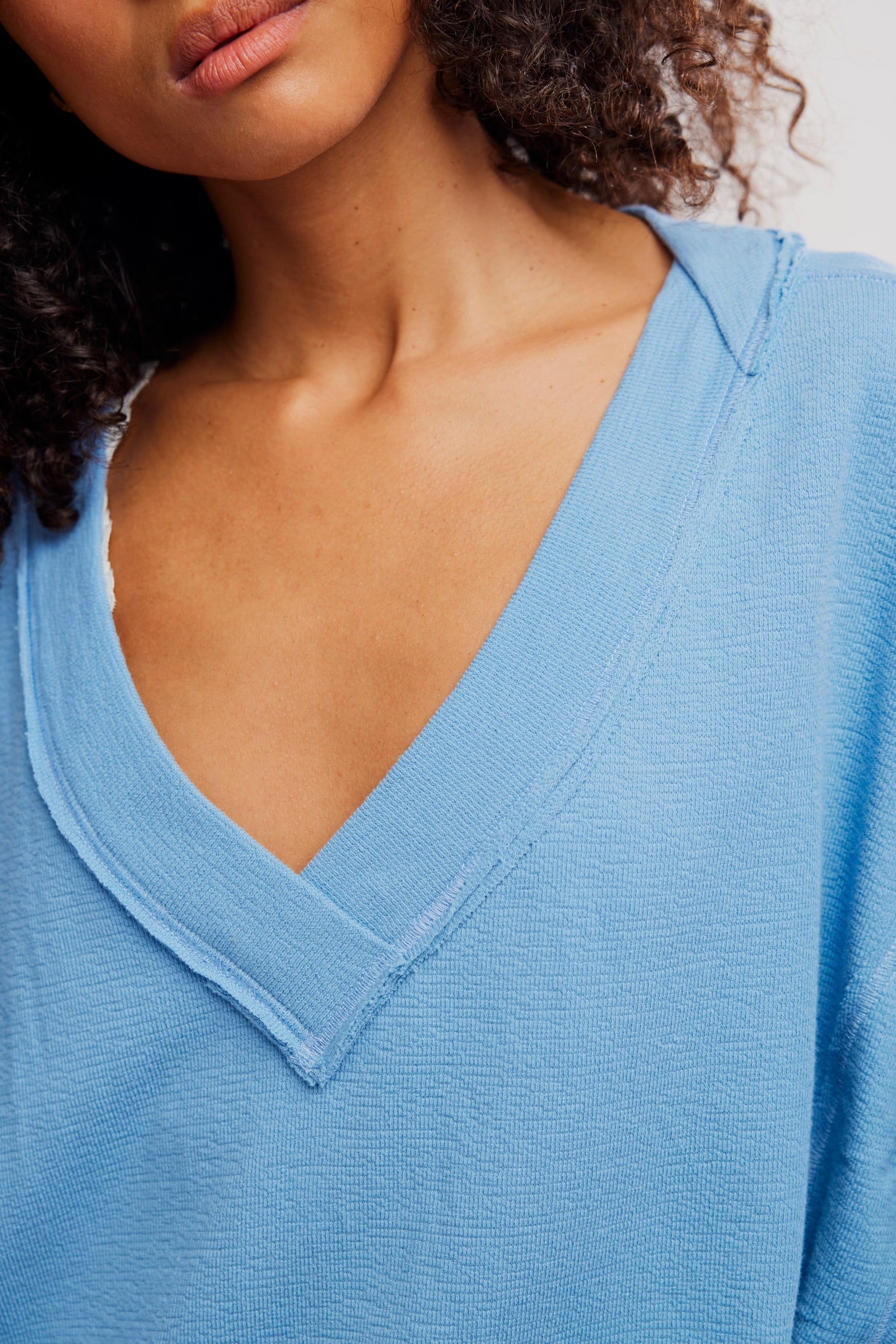 Close-up of a person wearing a blue V-neck sweater