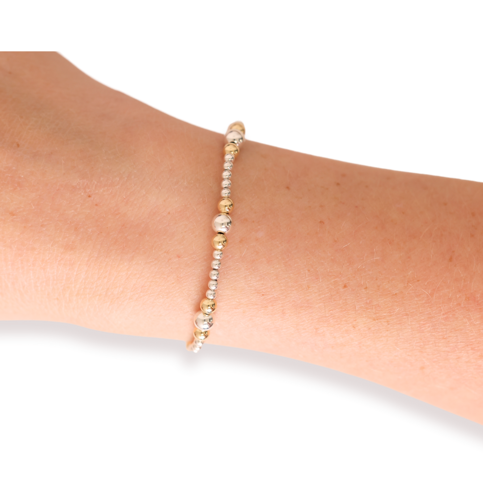 Beaded bracelet on a wrist with a plain background