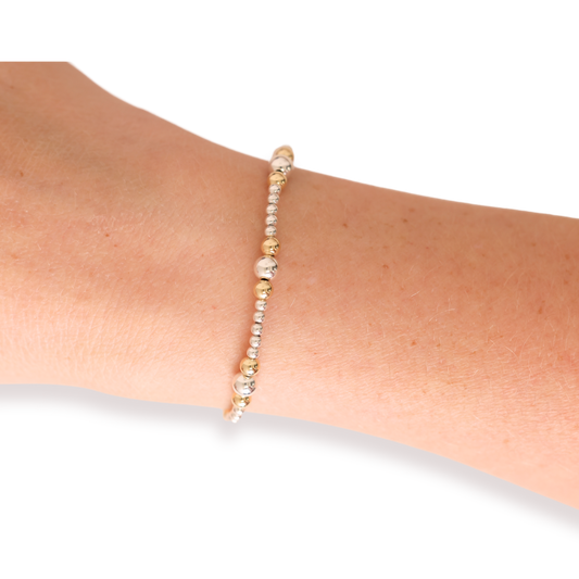 Beaded bracelet on a wrist with a plain background