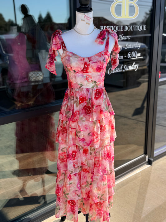Floral dress on a mannequin in front of a store window with 'DB Boutique' branding.