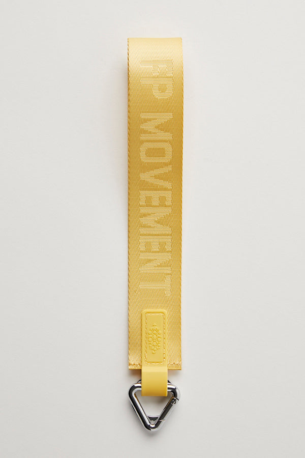 Yellow strap with 'FP MOVEMENT' branding on a light gray background