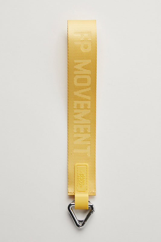Yellow strap with 'FP MOVEMENT' branding on a light gray background