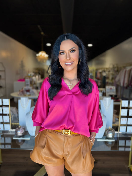 Brunette model in pink silky top inside boutique 