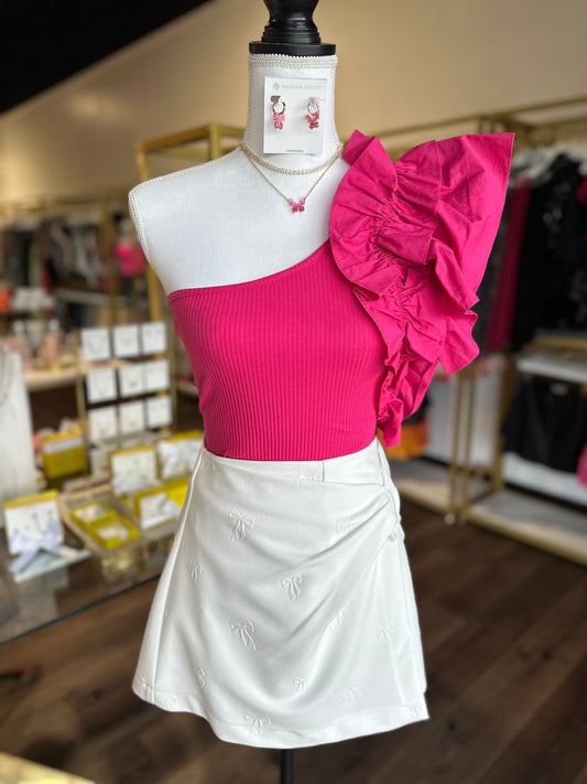 mannequin wearing pink bodysuit with ruffle sleeve and white skirt
