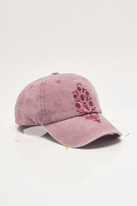 Pink baseball cap with floral embroidery on a white background