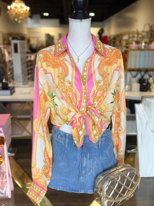 Mannequin wearing a patterned blouse and denim shorts with a handbag in a store setting.