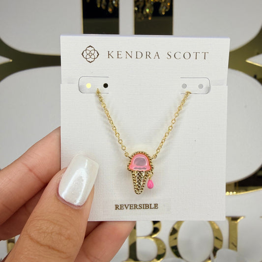 Kendra Scott necklace on a card held by a hand with a blurred background